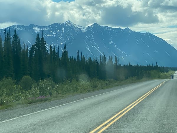 Empty two-lane highway curves through the Yukon wilderness