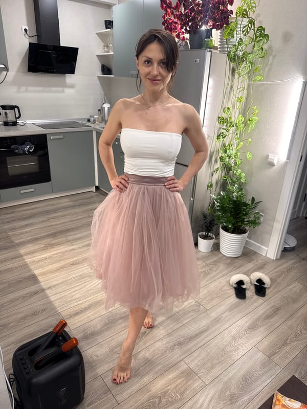Woman twirls in pink tulle skirt in Murino apartment kitchen