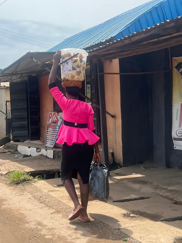 Everyday street life along a dirt path in Nkpor, Nigeria