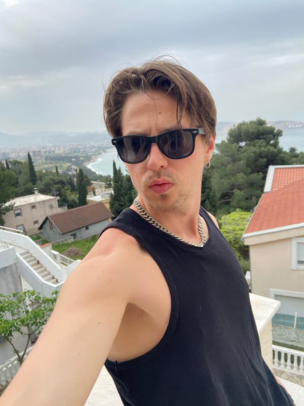 Tourist captures selfies on Montenegro balcony overlooking coastal town