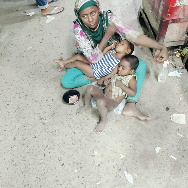Mother tends children, cat rests on ledge in Dhaka