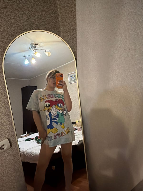 Person takes rotated mirror selfies in tie-dye shirt indoors