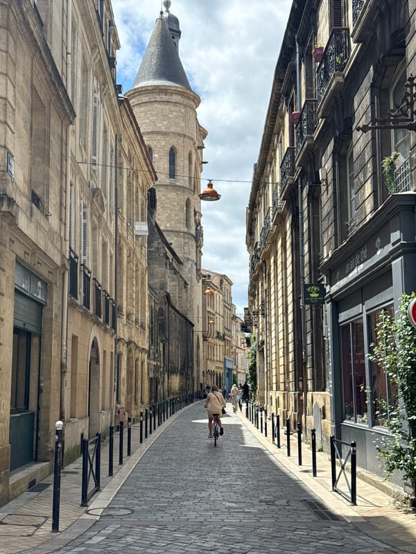 Tourist documents medieval Bordeaux streets during midday walking tour