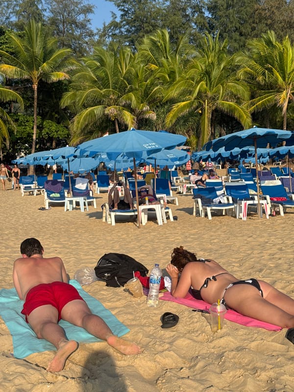 Sunbathers relax at Karon Beach in Thailand