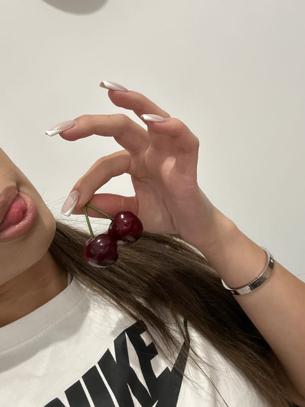 Person with cherries, ripe banana photographed at same location