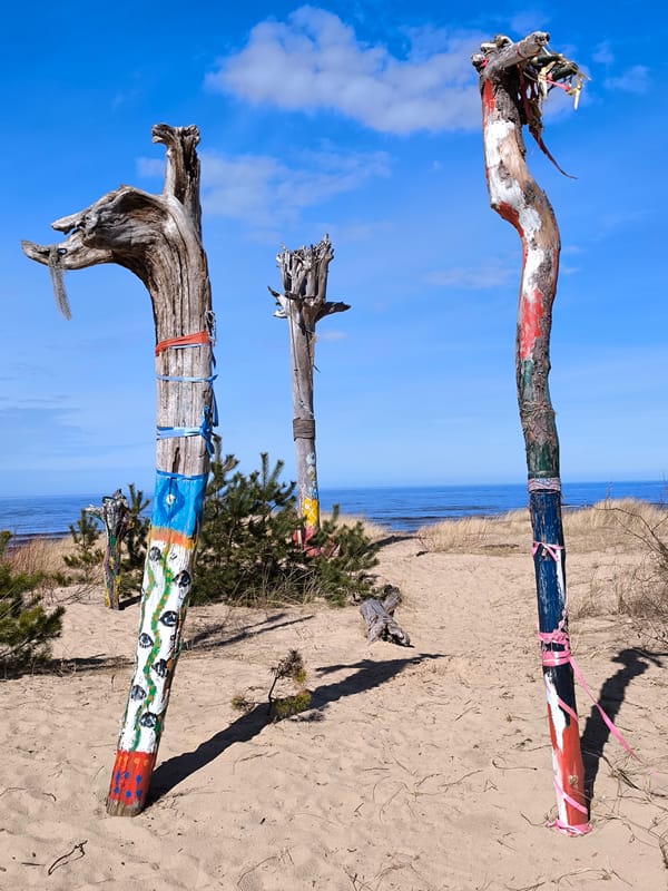 Woman documents colorful beach art installation in Gauja, Latvia