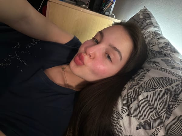 Woman poses with pursed lips, hashtag kiss image captured