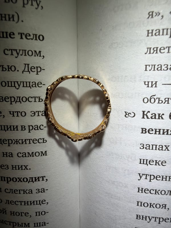 Gold crown ring photographed in artistic arrangements with books, flowers