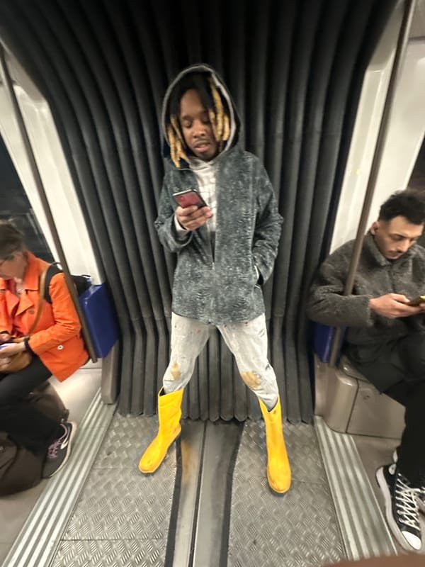 Metro passenger in yellow boots checks phone during evening commute