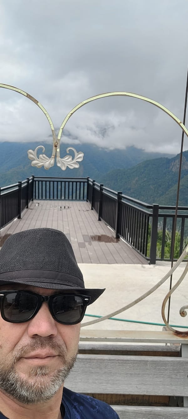 Observation deck selfie overlooking Milisi's forested mountain range