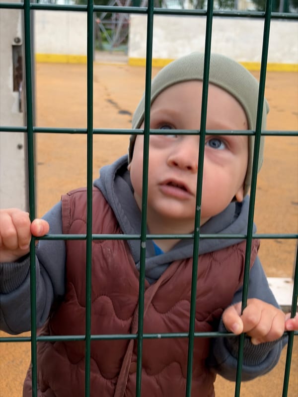 Toddler plays outside amid everyday residential life in Moskovskiy