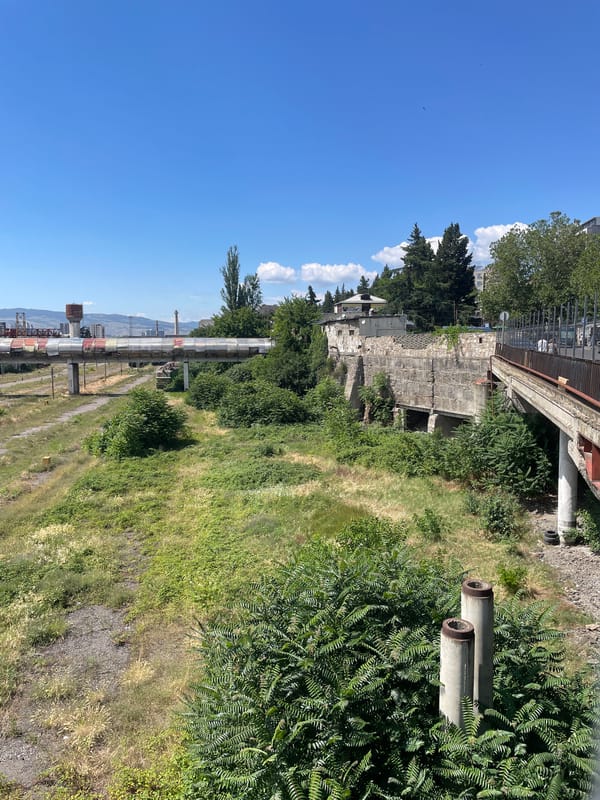Tbilisi train yards, street market, and urban edges on a clear morning