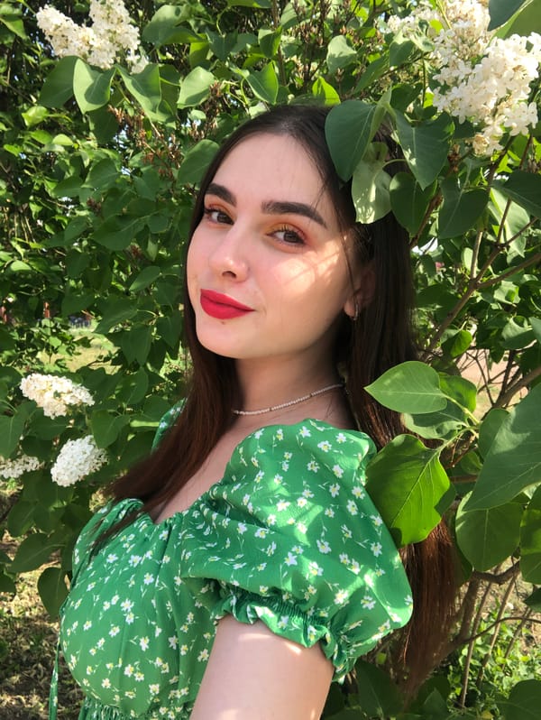 Woman poses with sunglasses among lilacs in Noviy photoshoot