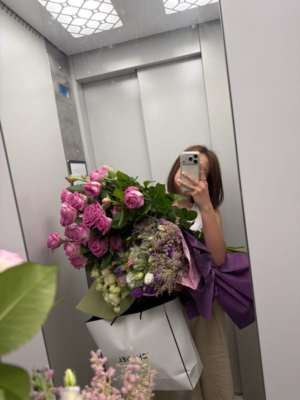 Woman takes elevator selfie with flower bouquet in Yerevan