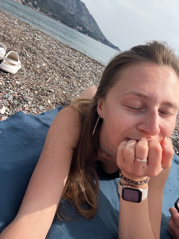 Woman sunbathes on pebble beach in Boreti, Montenegro