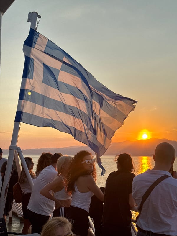 Greek flag flying on a boat at sunset near Kavala