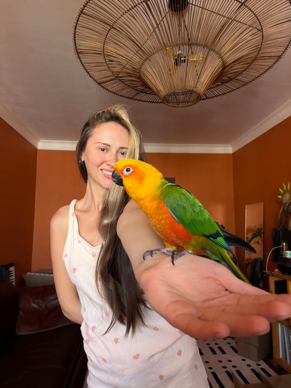 Woman poses with Sun Conure parrot in Khimki home