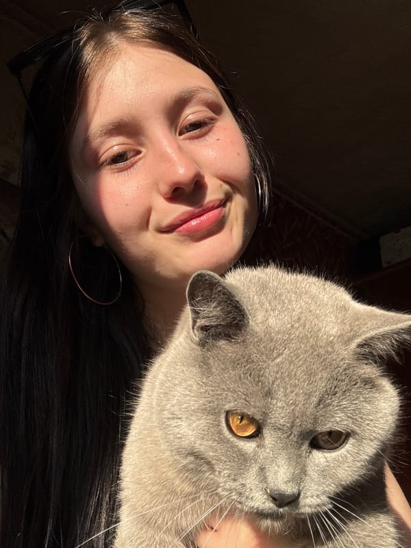 Person rests with gray cat in Foki, Russia