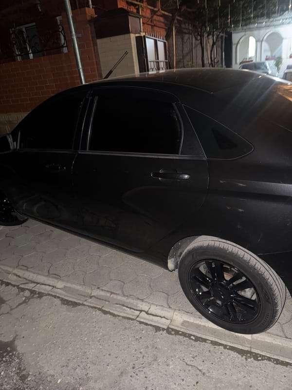 Person enters, inspects and starts black Lada vehicle at night