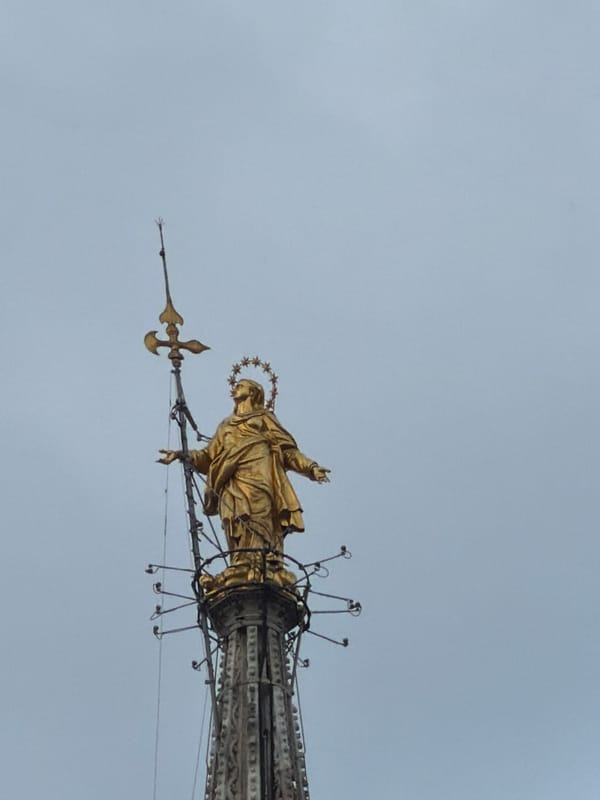 Visitor documents Milan Cathedral's Gothic details and golden Madonnina statue