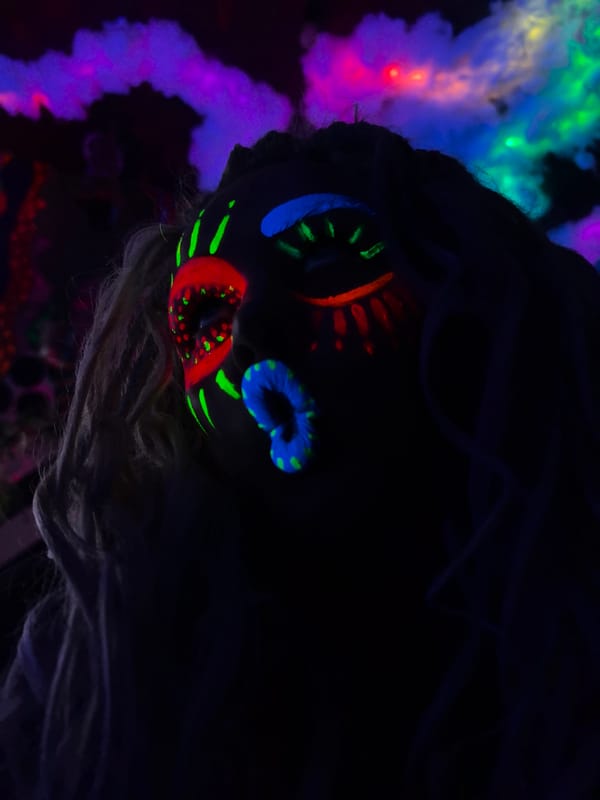 Neon face paint glows under blacklight at a night event in Russia