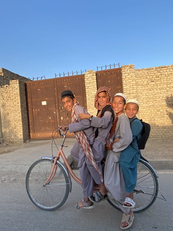 Four boys share bicycle ride in Kandahar