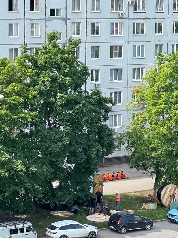 Construction crew resting under a tree in Tolyatti courtyard