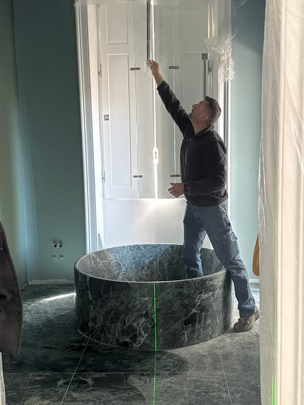 Worker stretches across marble counter in renovation site