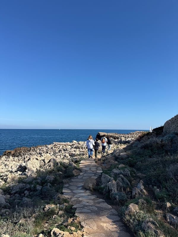 Visitors stroll coastal pathway in Antibes, France