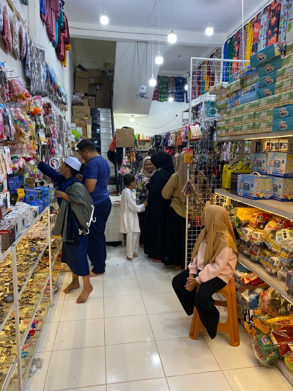 Browsing a packed mixed-goods market in Lamteumen Barat