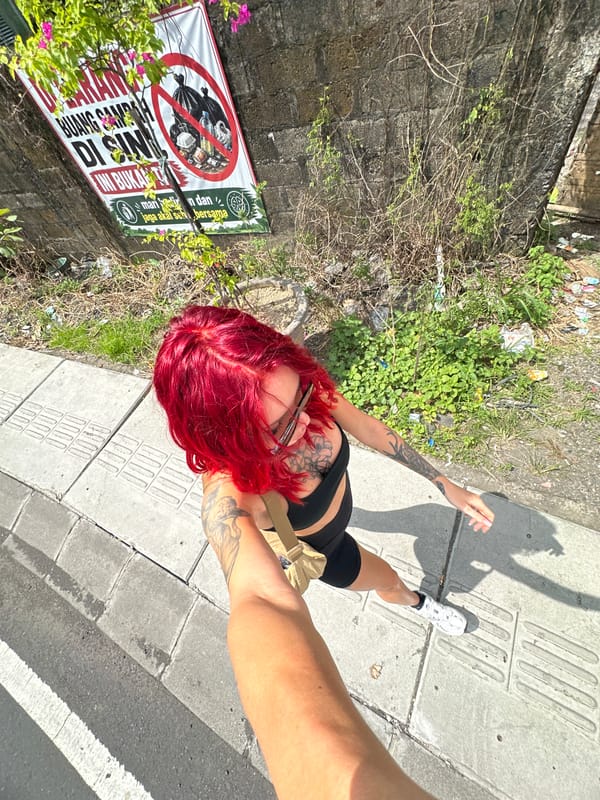 Tourist takes early morning selfies on North Kuta sidewalk