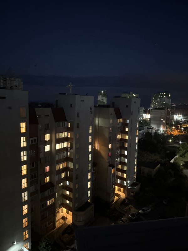 Orange moon rises over Odesa apartments on a summer night