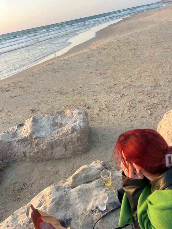 Woman sits on rocks at Bat Yam beach