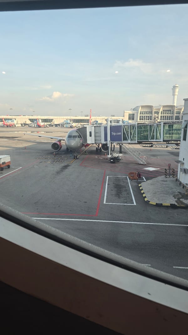 Aircraft parked at Trip.com-branded gate in Sepang airport