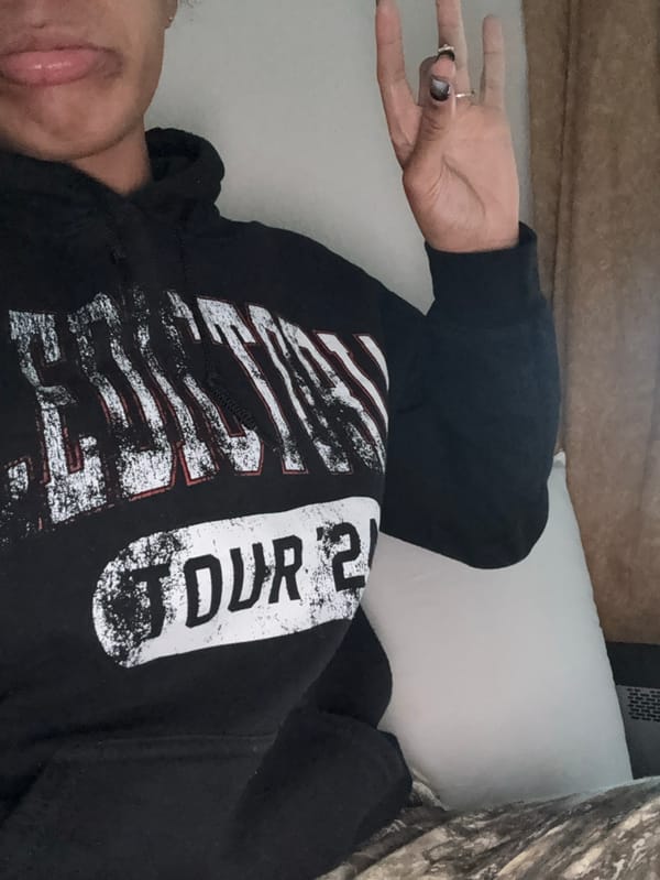 Person in tour hoodie rests on pillow in Yokosuka