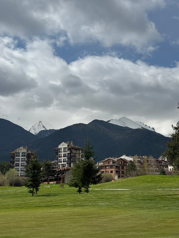 Morning golf game observed in Razlog against snowy mountain backdrop