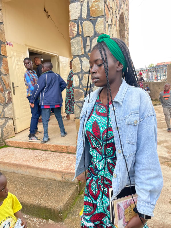 Everyday life outside a stone building in Jos, Nigeria