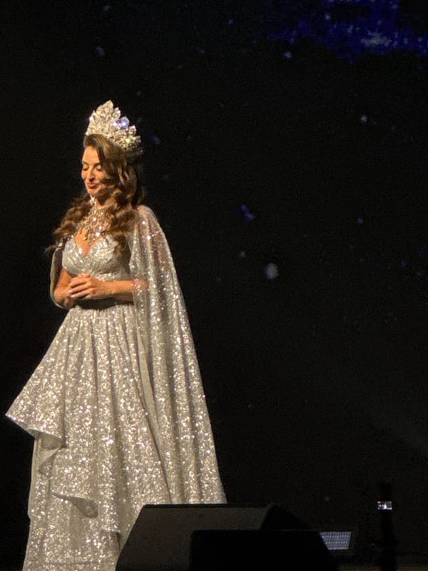 Beauty pageant contestant photographed on stage in evening gown