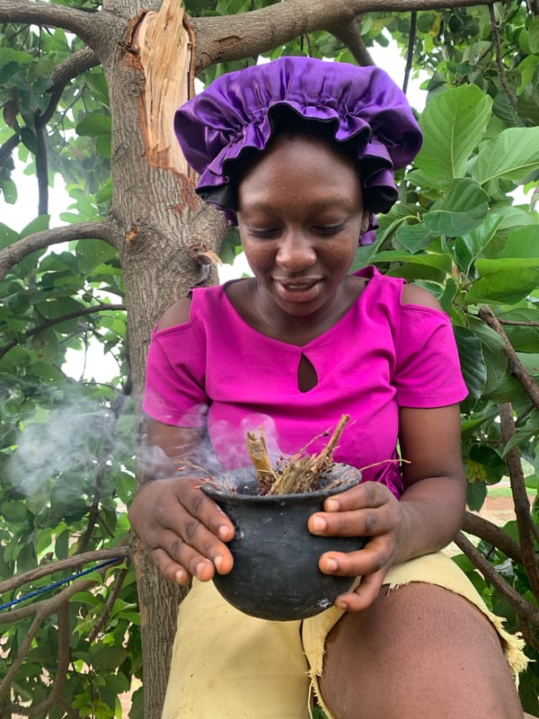 Woman conducts smoking ritual with pot in Agban, Nigeria