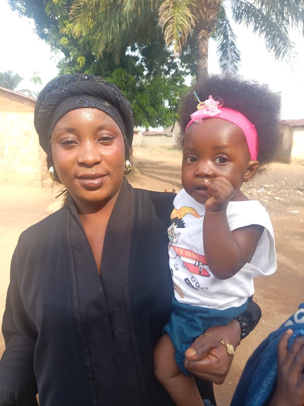 Woman holds baby in outdoor setting in Akwanga, Nigeria