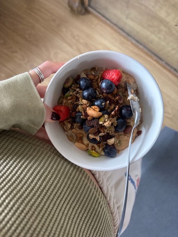 Person photographed eating breakfast indoors wearing denim cap