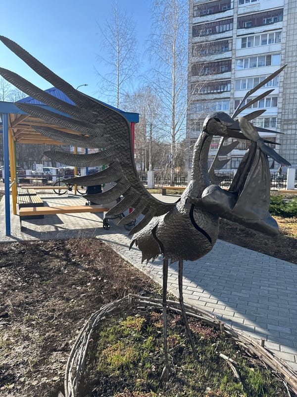 Urban spring morning: bird sculptures, nesting sparrow, city streets
