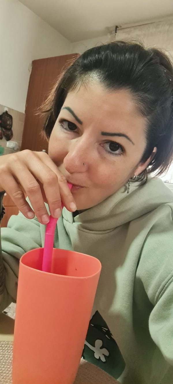 Woman drinks from orange cup in Nahariyya