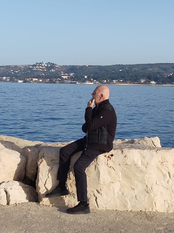 Couple sits by iconic Dénia lighthouse overlooking Mediterranean Sea