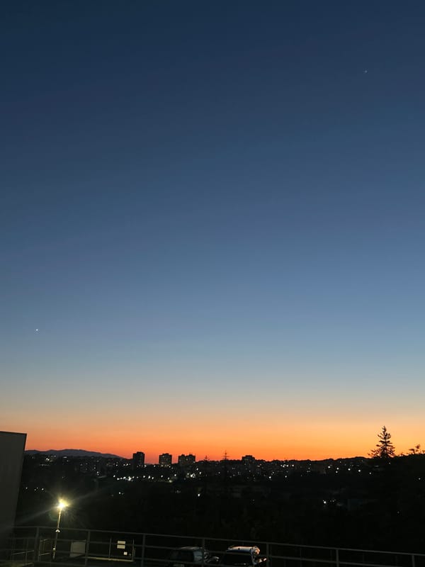 City skyline silhouetted against a dusk gradient sky
