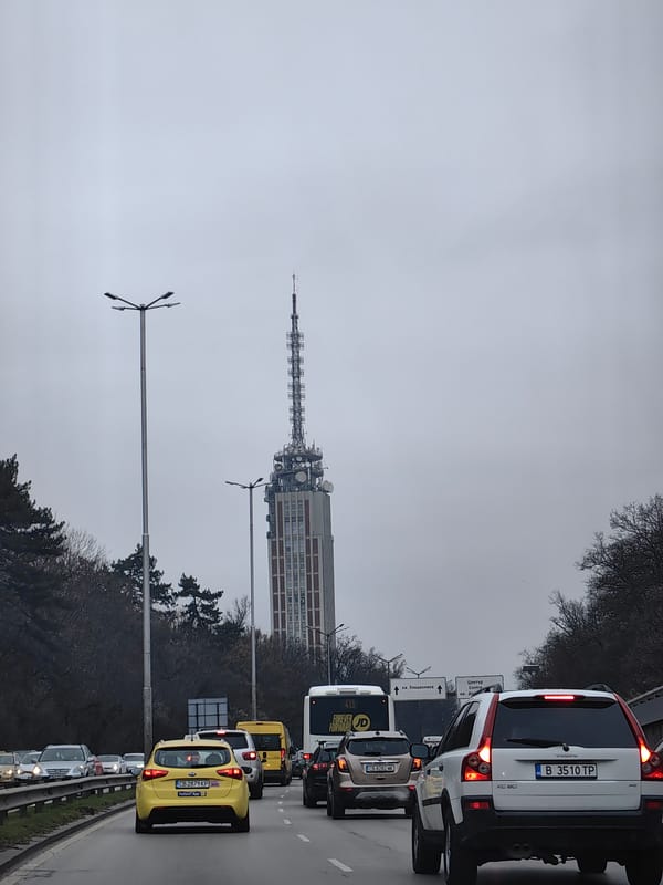 Sofia traffic scene with telecommunications tower on overcast day