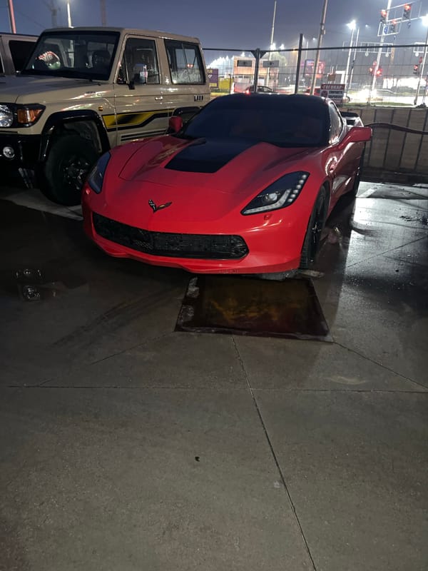 Red sports car parked over drain grate in Plovdiv