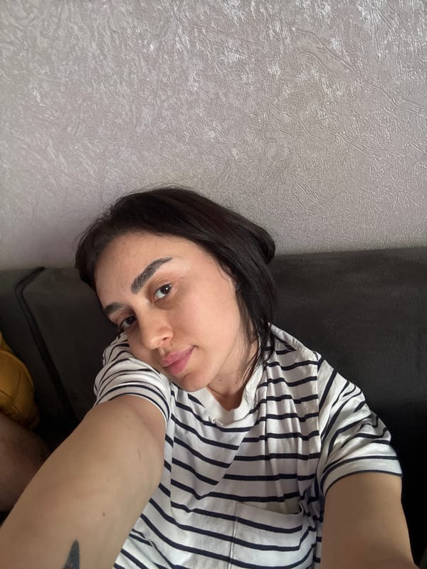 Woman in striped shirt rests indoors in Tbilisi