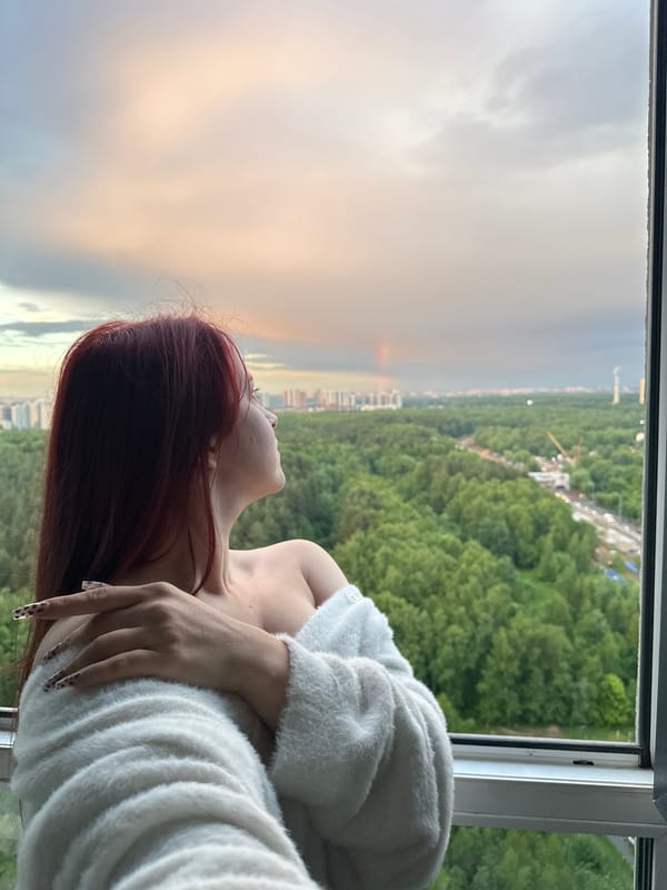 Rainbow appears over city forest after afternoon rainstorm