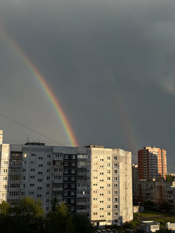 Double rainbow over wet streets in Rusanovo after summer rain